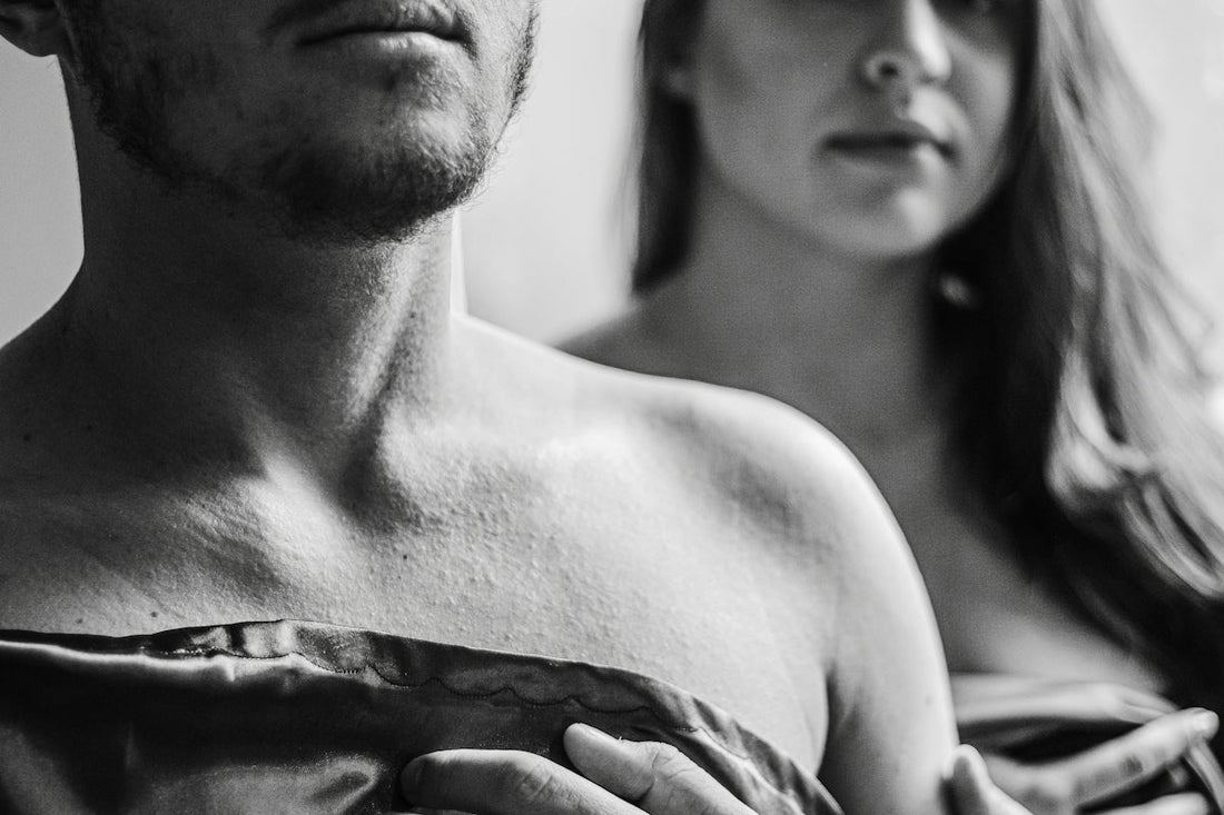 topless man covering face with blanket